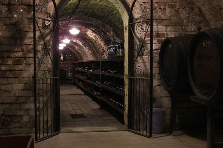 Entrance to a large wine cellar with iron gates that are standing open